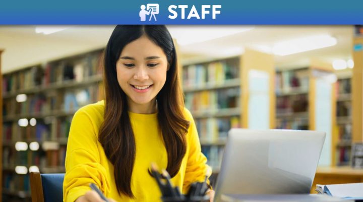 Woman preparing a report doing assignments laptop in a library