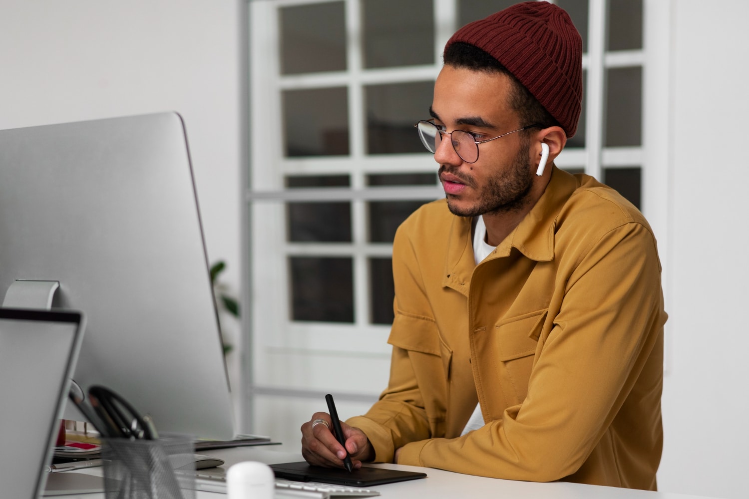 Male working on tablet looking at computer
